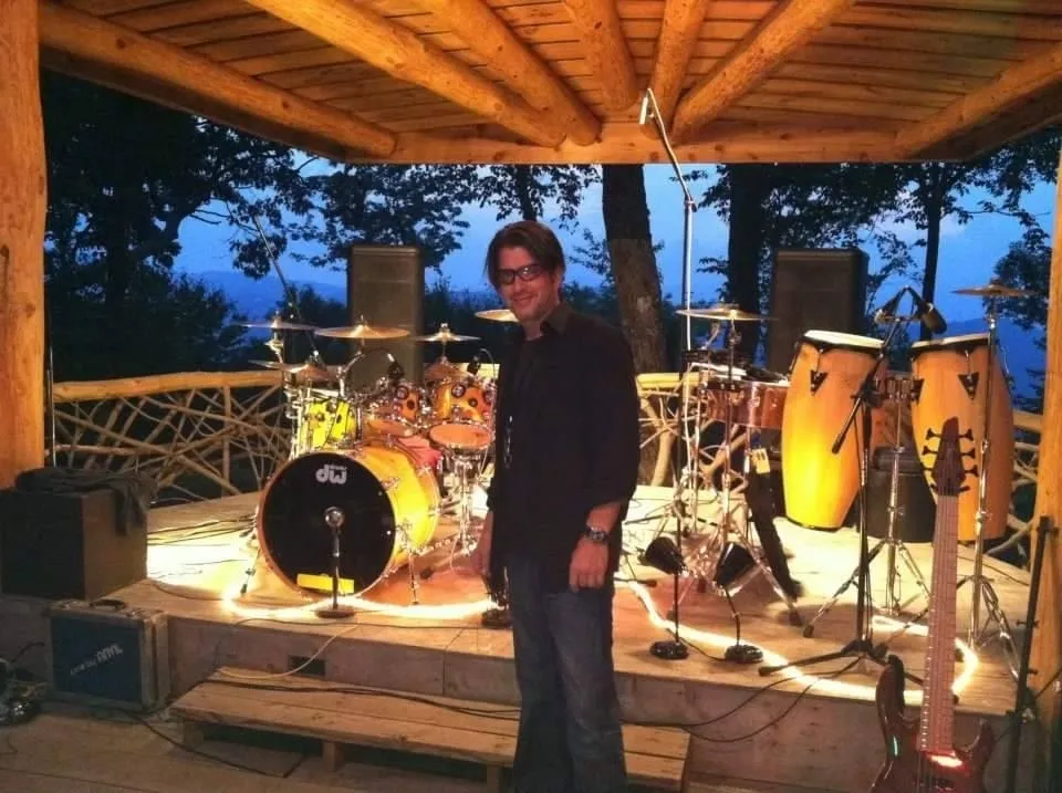 Man standing on stage with musical instruments.