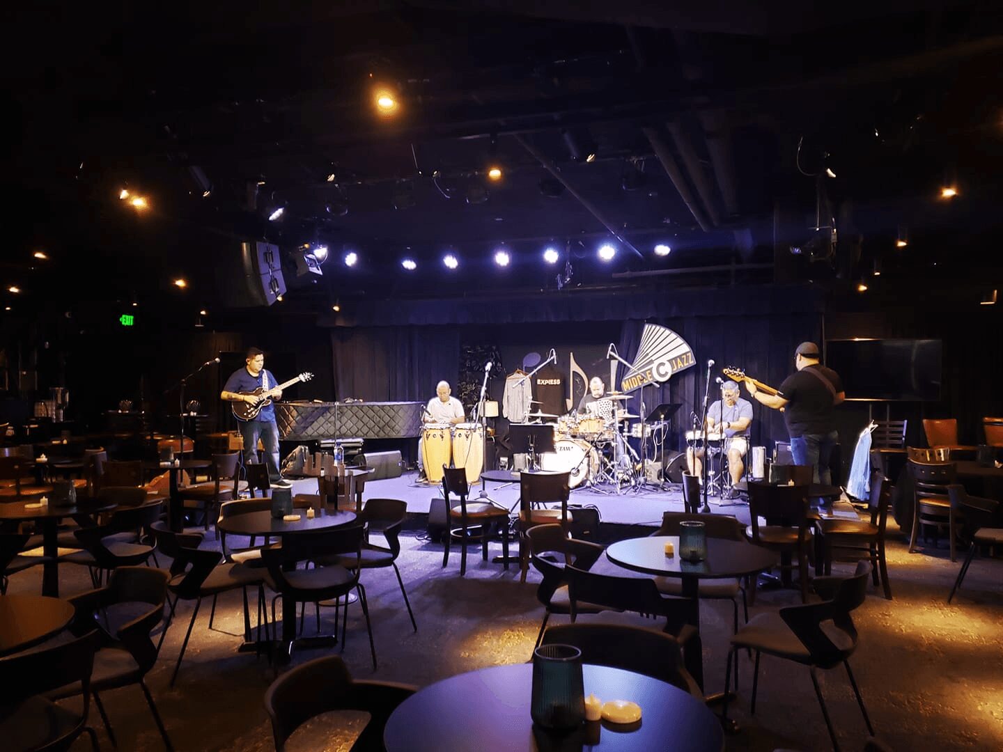 Live band performing in a dimly lit venue.